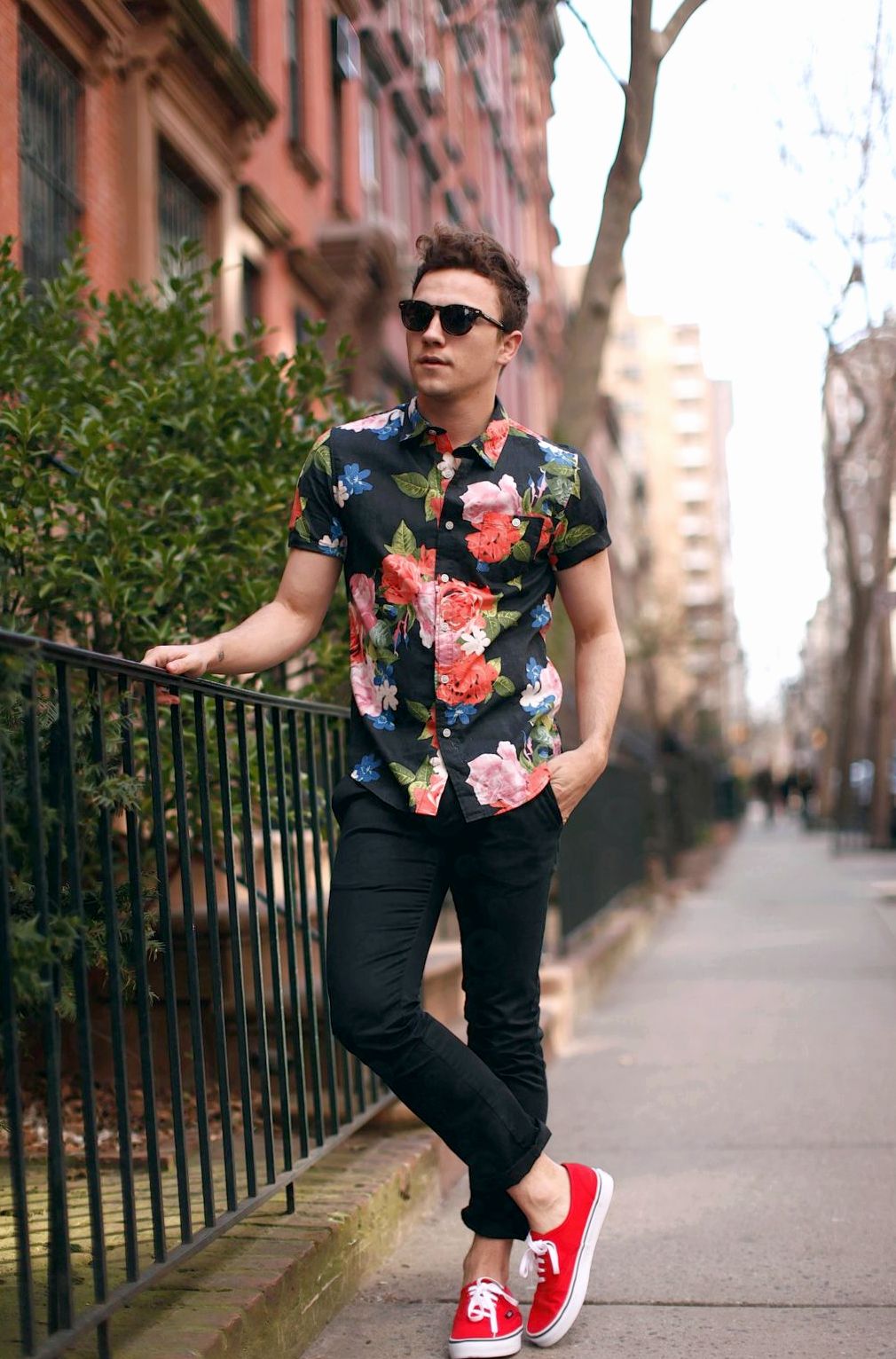 парень стоит в рубашке с цветочным принтом